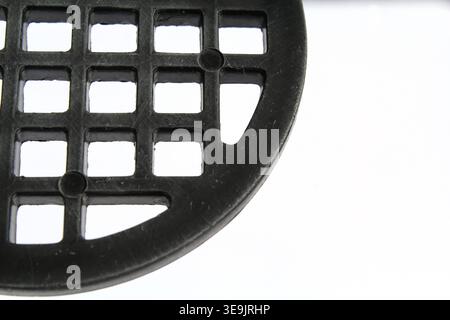 Close-up abstract of a black potato masher with a grid pattern of square holes Stock Photo