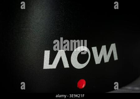 Macro closeup of Laowa camera lens branding on black metal surface with red accent showing photography equipment detail and texture Stock Photo
