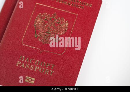 Closeup russian biometric passport cover showing gold emblem and textured crimson surface, studio lighting on white background, sharp detail for produ Stock Photo