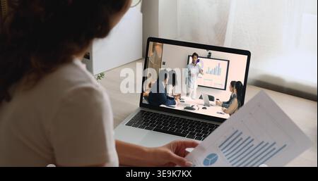 Team participating in videocall displayed on laptop screen Stock Photo