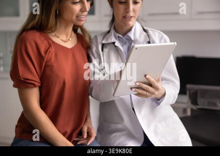 Therapist and patient using tablet for examining health test results Stock Photo