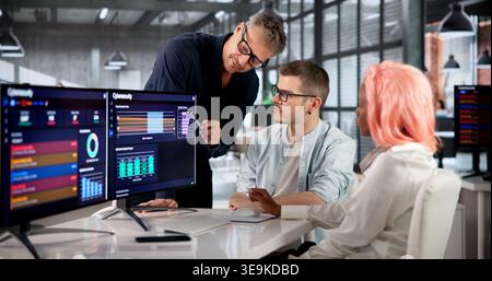 Cybersecurity Engineer Carefully Monitors Threats With Team Using Advanced Data Tools. Stock Photo