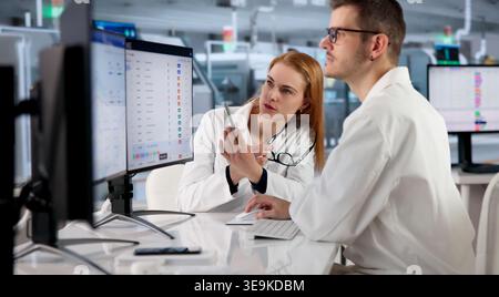 Factory Manager Monitors Real-time Production Data On Desktop Computer. Stock Photo
