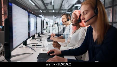 Customer Service Agent Attentively Answering Calls In Busy Contact Center. Stock Photo