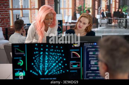 Programmer Collaborates With Diverse Team Analyzing AI Data For Security. Stock Photo