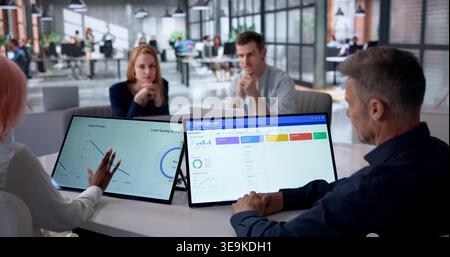 Marketing Manager Analyzes CRM Dashboard On Tablet To Boost Customer Loyalty. Stock Photo