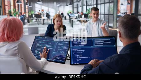 Software Engineers Collaborating Closely On Secure Code Review During Team Meeting. Stock Photo
