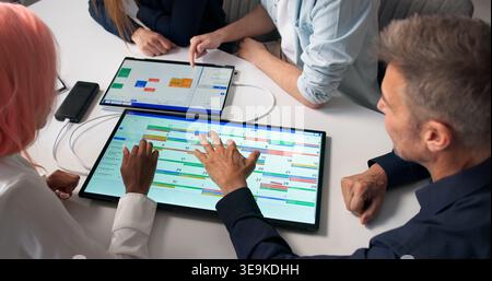 Project Manager Guiding Diverse Team Through Agile Planning On Digital Calendar. Stock Photo