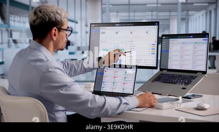ERP Expert Evaluates Cloud-Based Integrated Management Software On Laptop For Strategic Business Planning Stock Photo