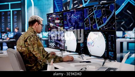 Army Officer Overseeing Several Computer Displays In A High-Tech Command Hub Stock Photo