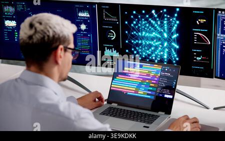 Engineer Analyzing Big Data And AI Model Training With Clustering On Multiple Screens Stock Photo