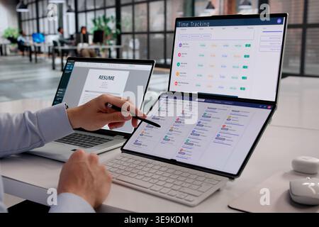 Human Resources Manager Analyzing Staffing Software Data On Laptop In Corporate Office Stock Photo