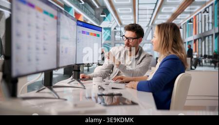 Two Software Developers Collaborate On CRM Functionality In Corporate Meeting Stock Photo