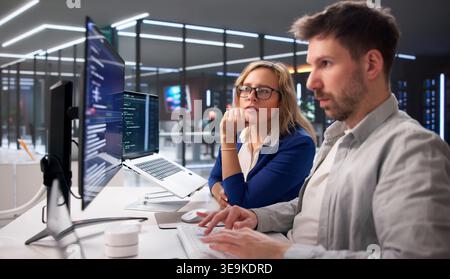 Tech Professionals Collaborating On Coding Projects In Contemporary Workspace Stock Photo