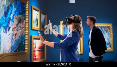 Museum Curator Engaged With Immersive Virtual Reality Display In Contemporary Gallery Stock Photo