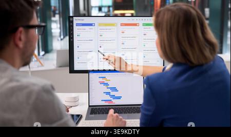 Project Coordinator Diligently Revises Event Timeline With Scrum Tool On Desktop Computer Stock Photo