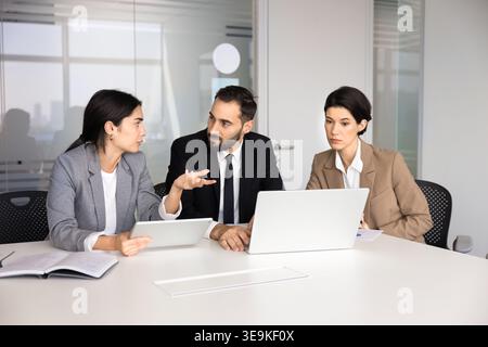 Diverse business professionals discussing project details during corporate strategy meeting Stock Photo