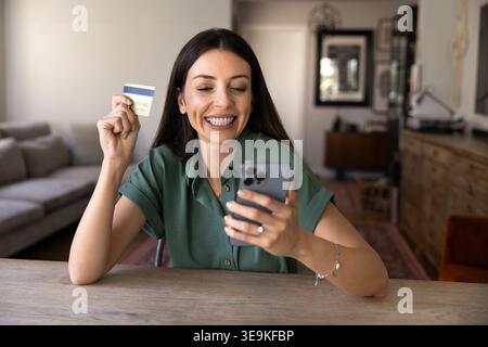 Woman making online payment with credit card at home Stock Photo