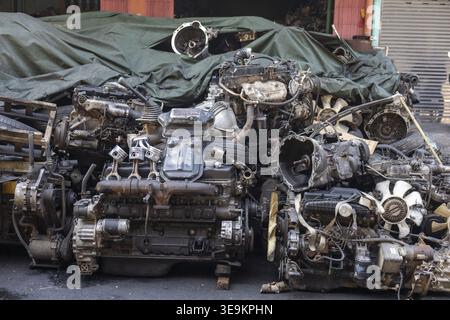 Huge scrap engine pile shows heavy metal parts resting in dirty junkyard conveying forgotten abandoned mood. Automotive mechanical components stacked Stock Photo
