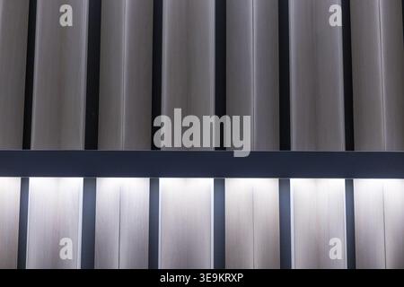 Abstract background of vertical metal panels with soft glowing illumination separated by dark horizontal divider creating calm modern architectural te Stock Photo