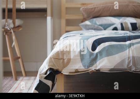 Warm bedding on a wooden bed in a simple room Stock Photo
