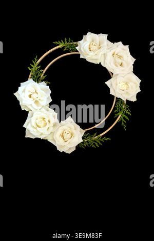 White rose flower on black background with two wooden circle frames and cedar leaf sprigs. Abstract symbol for logo, greeting card, invitation. Stock Photo