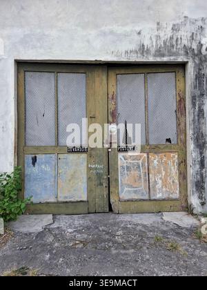 Rustic Weathered Wooden Double Doors with Peeling Paint and Textured Glass Stock Photo