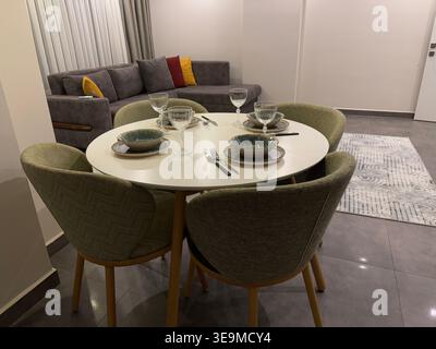 Modern dining room with round table set for four in cozy apartment interior. Mobile photo Stock Photo