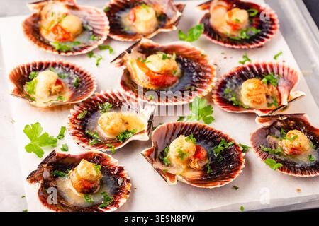 Cooked scallops with parsley on a baking sheet Stock Photo