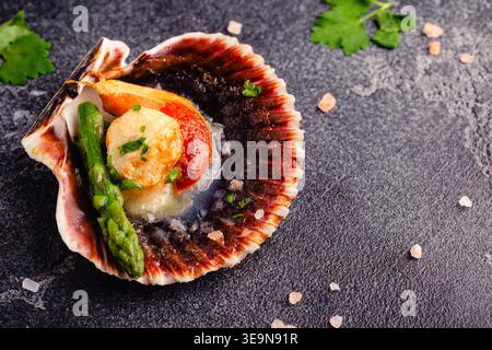 Cooked scallops with vegetables on a dark background Stock Photo