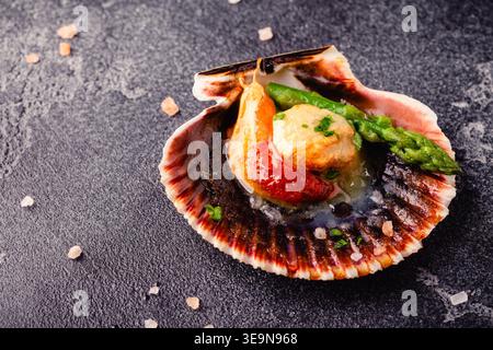 Cooked scallops with vegetables on a dark background Stock Photo