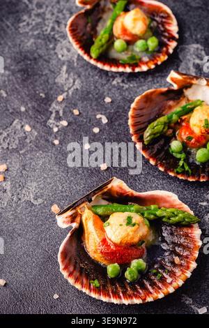 Cooked scallops with vegetables on a dark background Stock Photo