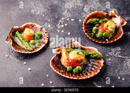 Cooked scallops with vegetables on a dark background Stock Photo