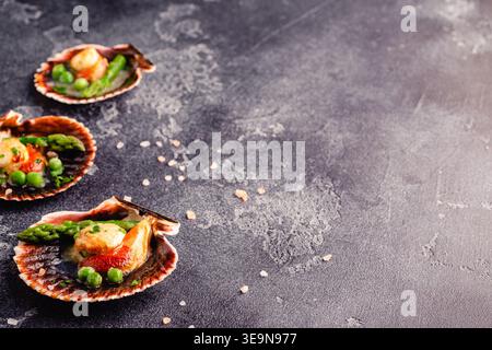 Cooked scallops with vegetables on a dark background Stock Photo