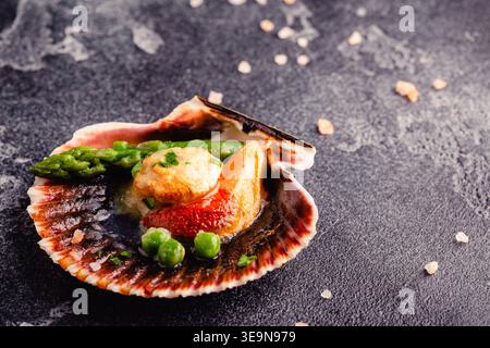 Cooked scallops with vegetables on a dark background Stock Photo