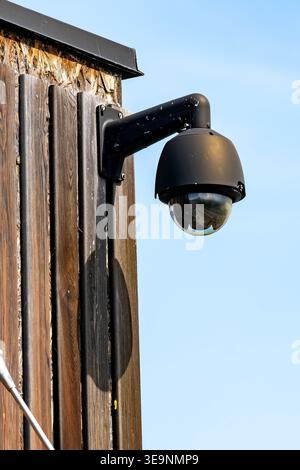 Outdoor Security Camera Mounted On Wooden Wall Surveillance Dome Camera With Blue Sky Background Stock Photo