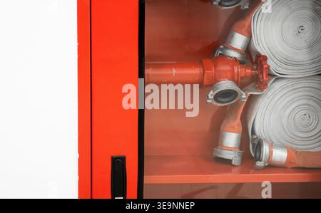 Fire hose reel cabinet for emergency safety and fire prevention equipment, readiness concept, protecting lives and property Stock Photo