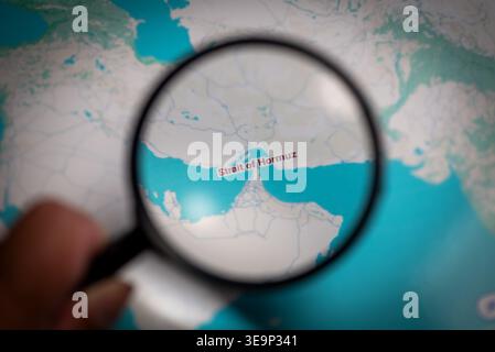 Strait of Hormuz Highlighted on Map with Magnifying Glass Stock Photo