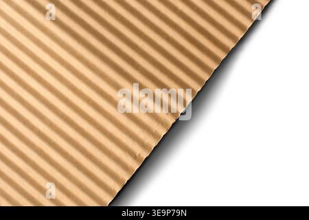 brown corrugated paper sheet isolated white background, diagonal ridges with rough edge, top view with shadow, stationery mockup template Stock Photo