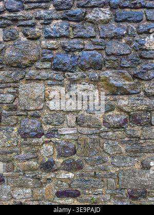 A wall made of stone with a rough texture. The wall is gray and has a blue hue Stock Photo