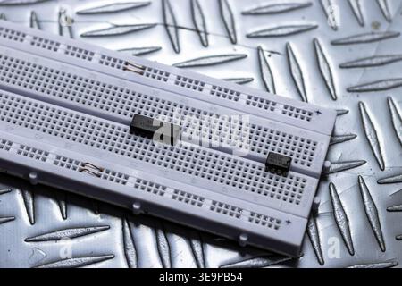 A white board with a black object on it. The board is on a metal surface Stock Photo