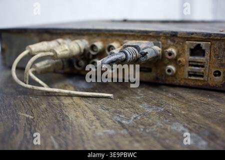 Cut the cord with this obsolete old electrical equipment on an old worn wooden desk. Stock Photo