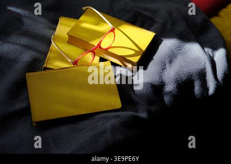stack of yellow books and spectacles in the morning sunlight, education,reading,literature,novel,inspiration,relaxing concept Stock Photo
