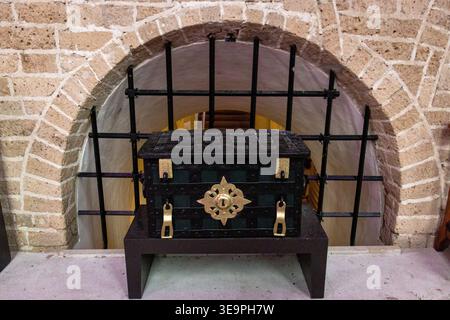 A black box with gold trim sits on a ledge in front of a brick wall. The box is ornate and has a gold trim, which gives it an elegant and sophisticate Stock Photo