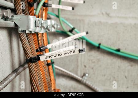 Electrical grounding and bonding busbar system. Close up. Labeled grounding rods in electrical room. Copper conductors, clamps, and grounding electrod Stock Photo
