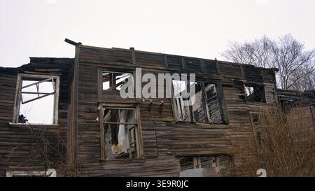 Abandoned Wooden House Ruined by Fire with Charred Walls Stock Photo