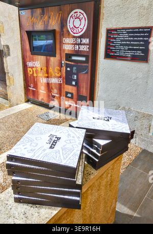 Large stack of more than a dozen pizza boxes awaiting collection next to a 3-minute pizza vending machine - Le Blanc, Indre (36), France. Stock Photo