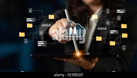 Professional individual uses a tablet for uploading data to the cloud, showcasing modern technology and digital connection in a dynamic office Stock Photo