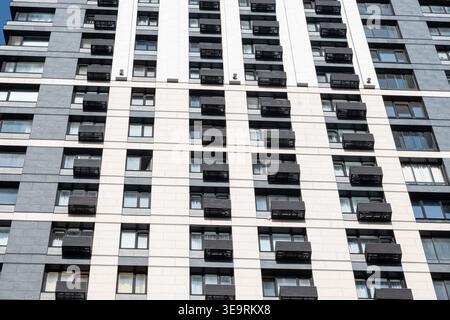 Modern residential building facade with geometric repeating balconies and windows, urban architecture and real estate concept Stock Photo