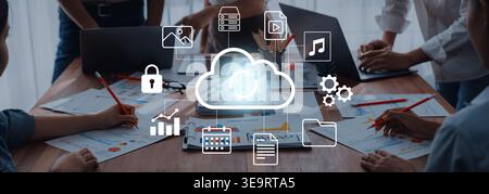A modern collaborative workspace illustrates cloud technology with various digital icons. The image represents teamwork, data management, and Stock Photo